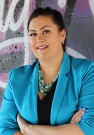 Principal Brittainy McGillis Principal Brittainy McGillis standing in front of a graffitied wall